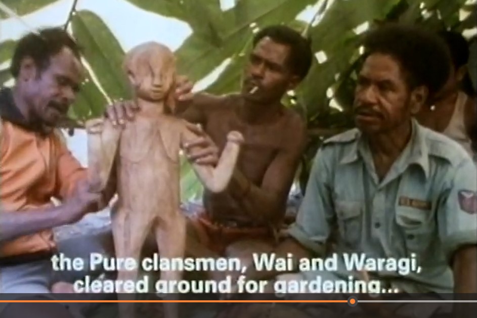 Reginald Bidogo et deux compagnons préparent une statue en bois de l'esprit ancestral.