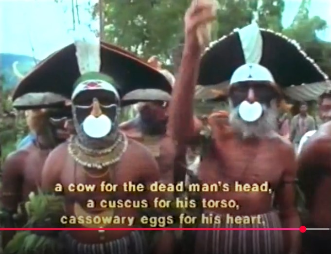 Kerua et son ami sont parés pour la grande cérémonie de réconciliation au village de Kindau dans les Hautes Terres. Le sous-titre traduit leur parole: "une vache pour la tête de l'homme mort, un couscous pour son torse, des œufs de casoar pour son cœur".