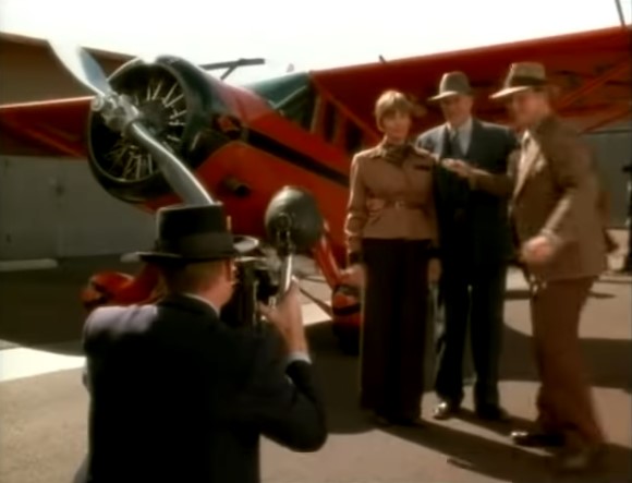 Amelia Earhart (Diane Keaton) et son mari George Putnam (Bruce Dern) se font photographier devant leur avion rouge.