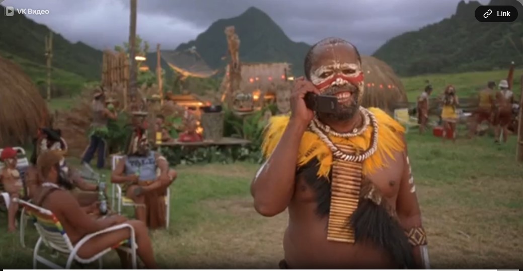 Le bigman papou Sulukim (Zakes Mokae), dans son village des highlands, téléphone avec son portable à Shelly, la fille de Krippendorf, pour lui dire que tout s'est bien passé.