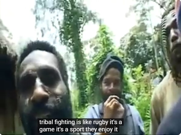 Un groupe de combattants papous dans un village. La légende indique: "la guerre tribale, c'est comme le rugby; c'est un jeu, c'est du sport, et ils y prennent plaisir."