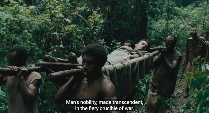 Des brancardiers papous portent le soldat blessé Max (Simon Stone). La légende indique en anglais: "la noblesse de l'homme est transcendée dans le creuset ardent de la guerre."