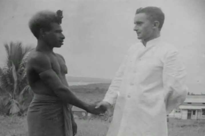 Le père John Nilles, alors jeune missionnaire, serre la main d'un Papou.