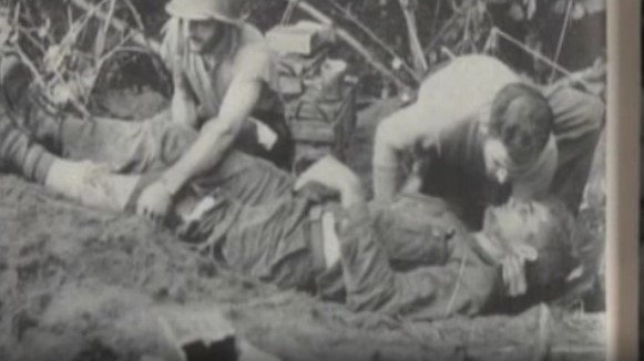 Deux soldats américains soignent leur camarade blessé pendant la campagne de Kapa Kapa - Buna en Papouasie.