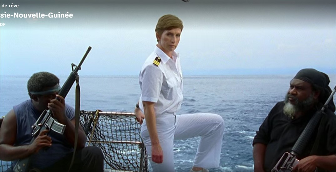 La doctoresse de bord Hanna Lauterberg (Fanny Stavjanik) se retrouve entourée de deux pirates papous armés de fusils-mitrailleurs.