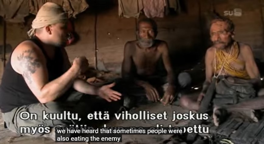 Riku Rantala, son guide Sam Ifid et le vieux Wan Veto sont assis dans une case; Riku déclare qu'il a entendu que parfois les gens mangeaient leurs ennemis.