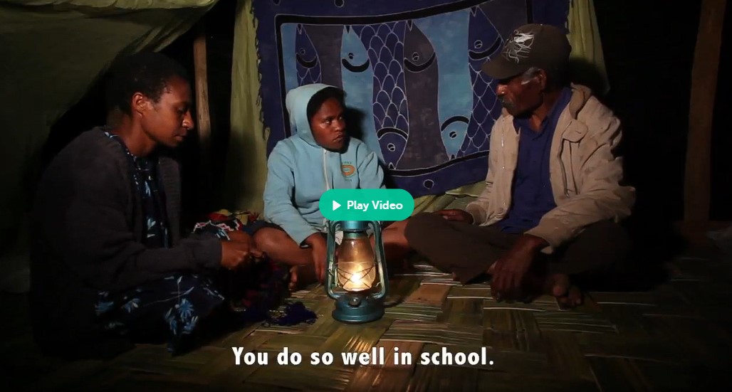 La jeune Aliko (Moslyn Moses), entourée dans sa case par ses parents Mariona (Tabitha Albert) et Kilen (Inapero Susure), qui lui disent qu'elle réussit bien à l'école.