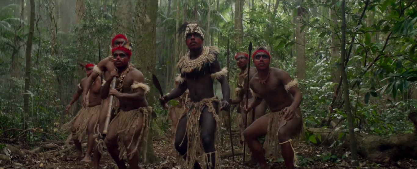 Dans la jungle papoue, une tribu de guerriers en armes autour de son chef (Ian Taatu) paré de coquillages.
